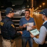 Motorista de caminhão Scania dentro da cabine recebendo mensagem de acesso negado pela gerenciadora de risco no celular — Nobre Advocacia